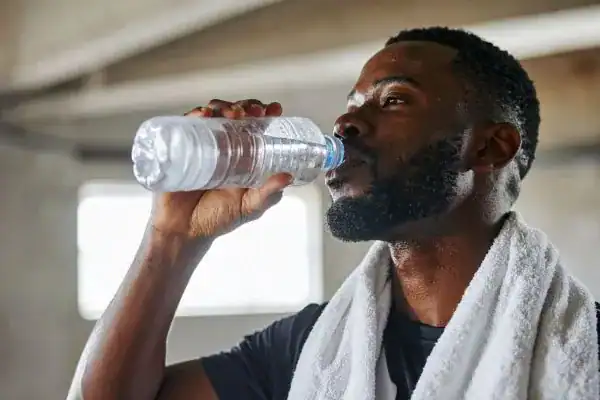 Hydration: The Secret Ingredient for a Toned Stomach and Enhanced Fitness 1 Image of man drinking water to improve hydration Harrow after work out.